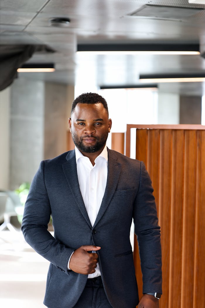 Confident businessman in a suit standing in a modern office building in Copenhagen.